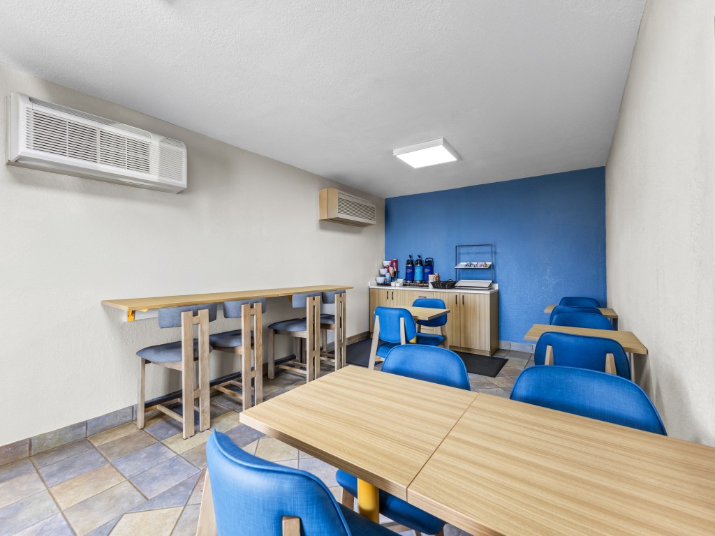 Breakfast area at Park Inn Wells with blue chairs and spacious seating.